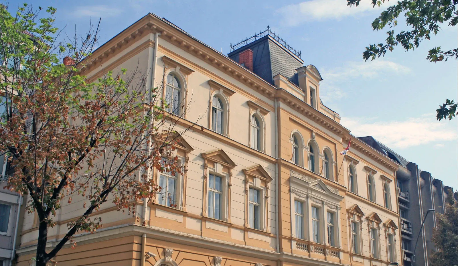 Fasada gradske zgrade u Šapcu sa drvećem u prvom planu